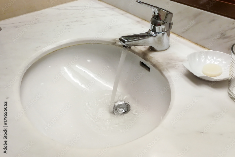Modern hygienic wash basin with running water from tap faucet Modern hygienic wash basin with running water from tap faucet