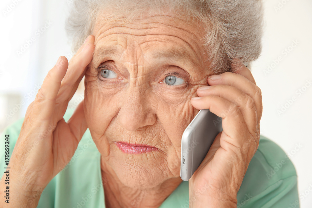 Elderly woman speaking on cell phone at home Elderly woman speaking on cell phone at home