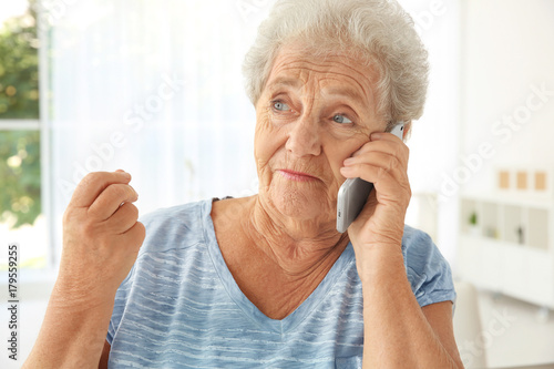 Elderly woman speaking on c...
