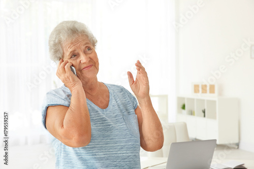 Elderly woman speaking on c...