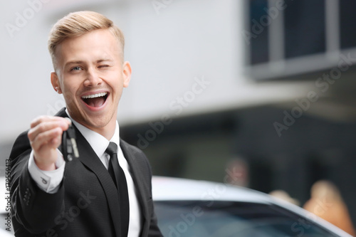 Young car salesman in forma...