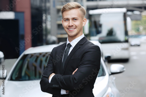 Young car salesman in forma...