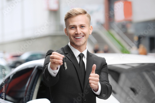Young car salesman in forma...