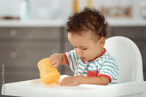 Cute baby with bottle of wa...