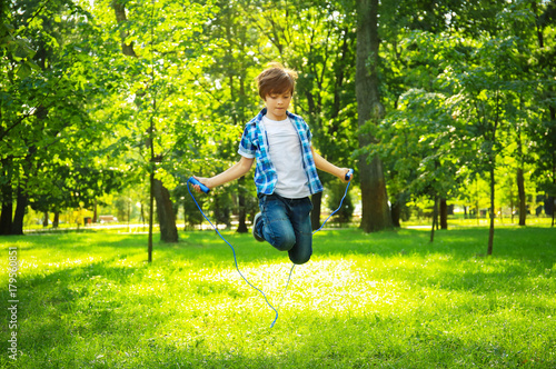Cute little boy jumping rop...