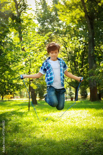 Cute little boy jumping rop...