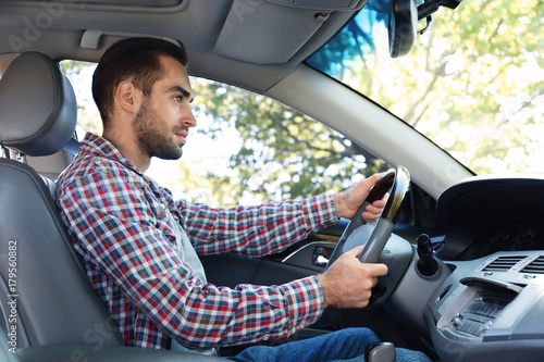 Young man on driver seat of...