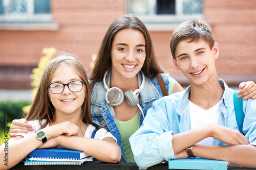 Happy students with books o...