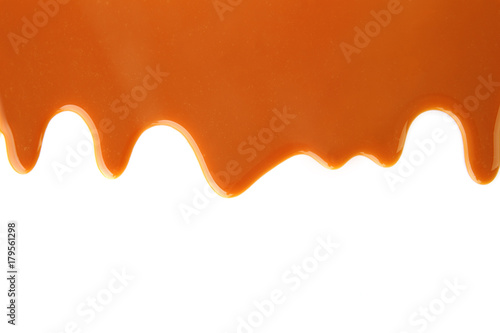 Flowing caramel sauce  isolated on white