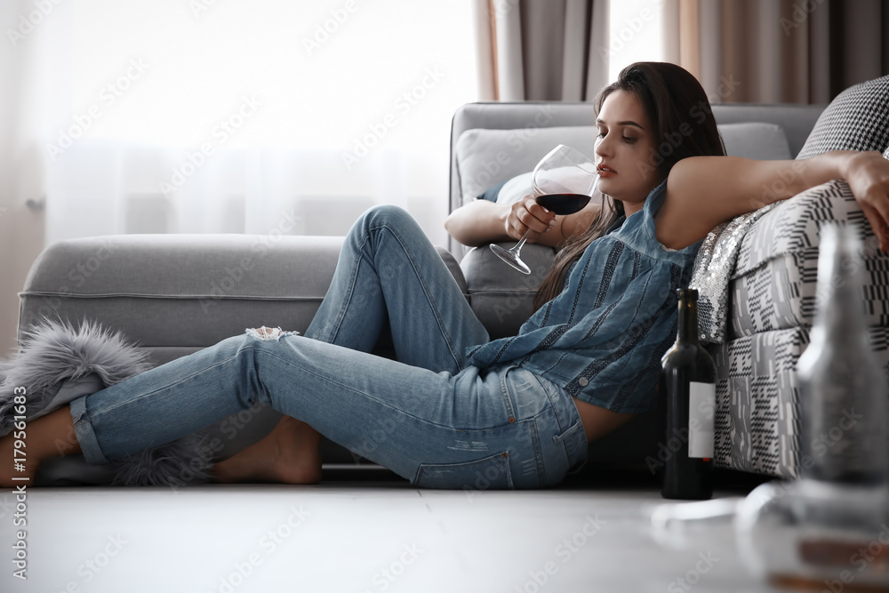 Young woman drinking alcohol at home Young woman drinking alcohol at home