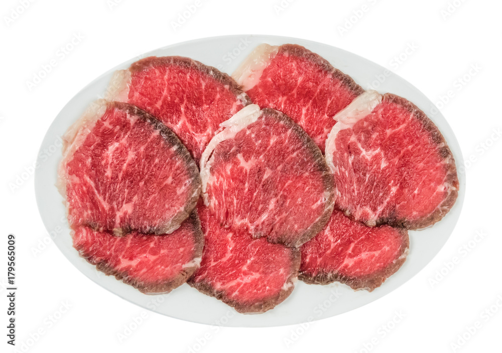 raw beef fillets on a plate .