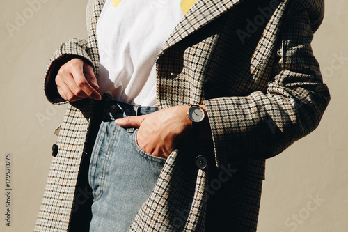 close up fashion details, young fashion blogger wearing black and white modern watch and a checked double breasted coat. ideal fall outfit accessories.