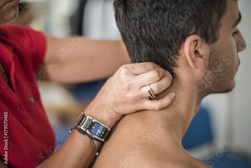 fisioterapista massaggia giovane paziente per curare un dolore cervicale