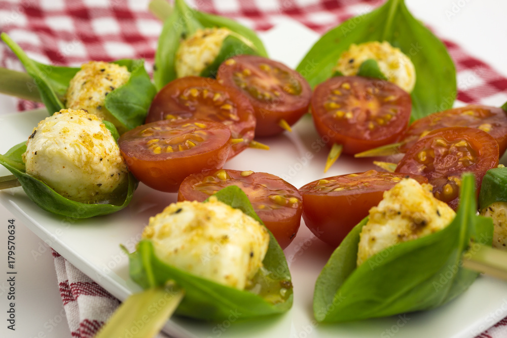 mini mozzarella ball in a basil leaf, marinated in pepper, lemon and olive oil with cherry tomato mini mozzarella ball in a basil leaf, marinated in pepper, lemon and olive oil with cherry tomato