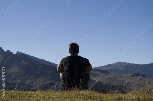 Boy thinking on the top of a mountain