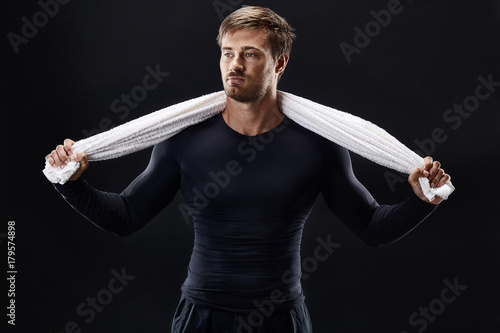 Portrait of a fitness man with towel on shoulders looking away. Happy young man relaxing after training. photo