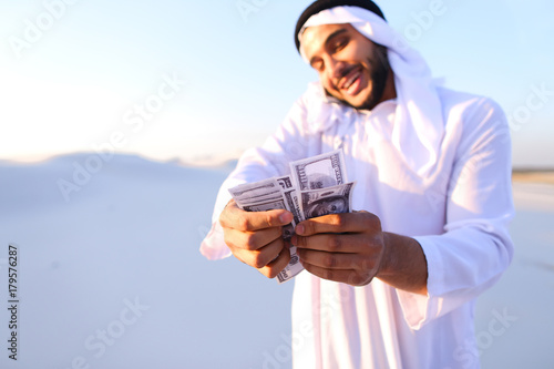 Foto Muslim male businessman talks on phone and shares news with comp