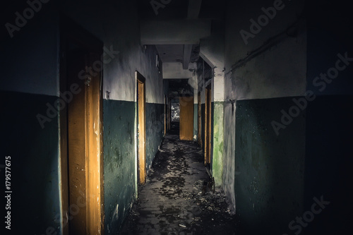 Cuadro en lienzo Walkway in creepy abandoned building, dark scary corridor with many doors, horro