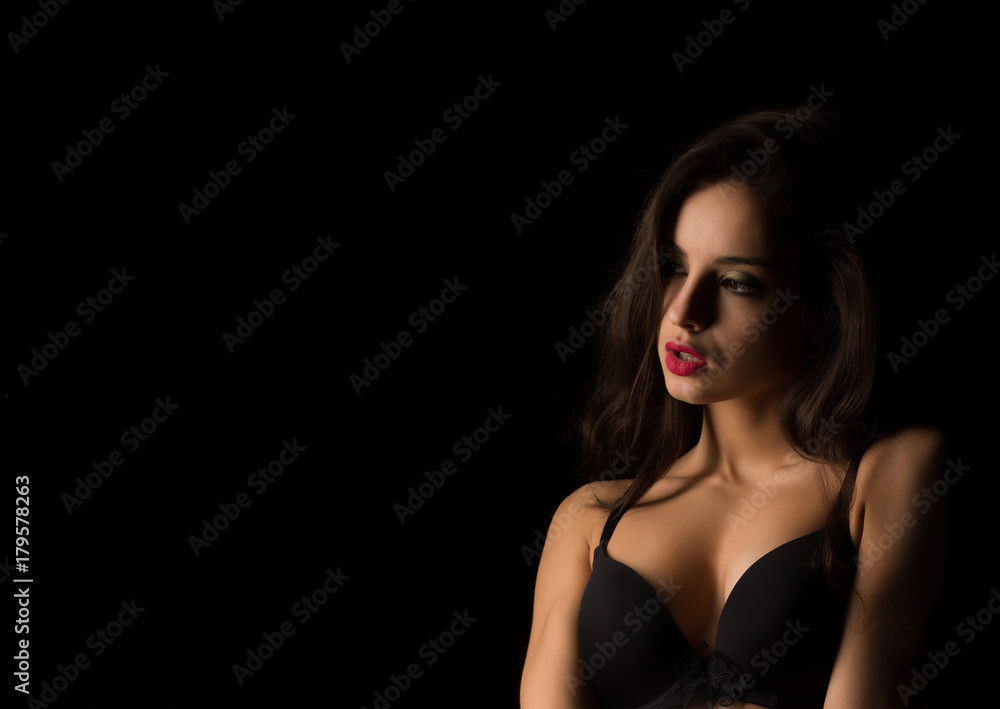 Closeup shot of sensual model with bright makeup posing with naked shoulders in the shadow Closeup shot of sensual model with bright makeup posing with naked shoulders in the shadow