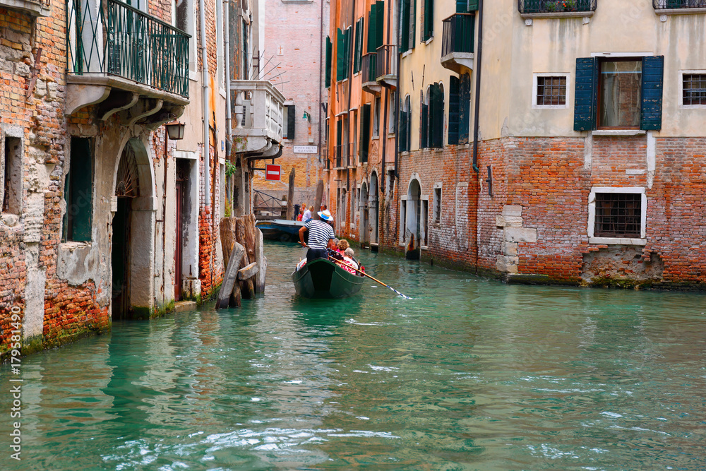 Tourists ride on a gondola. VENICE, ITALY