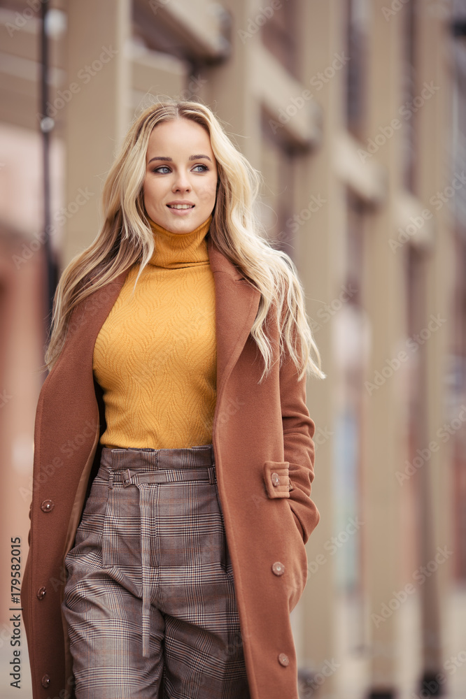 Blonde woman wearing in stylish coat in city
