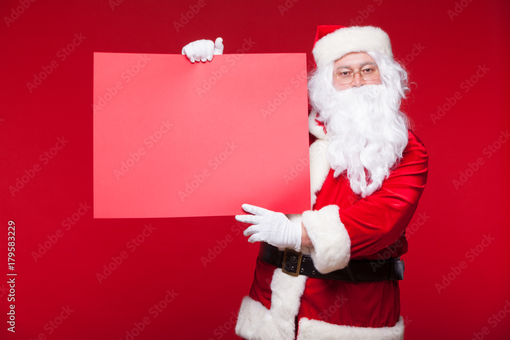 Santa Claus pointing in blank advertisement banner isolated on red background with copy space red leaf Santa Claus pointing in blank advertisement banner isolated on red background with copy space red leaf