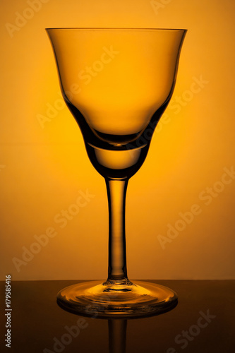 Figured wine glass for sherry on a background of orange spotlight