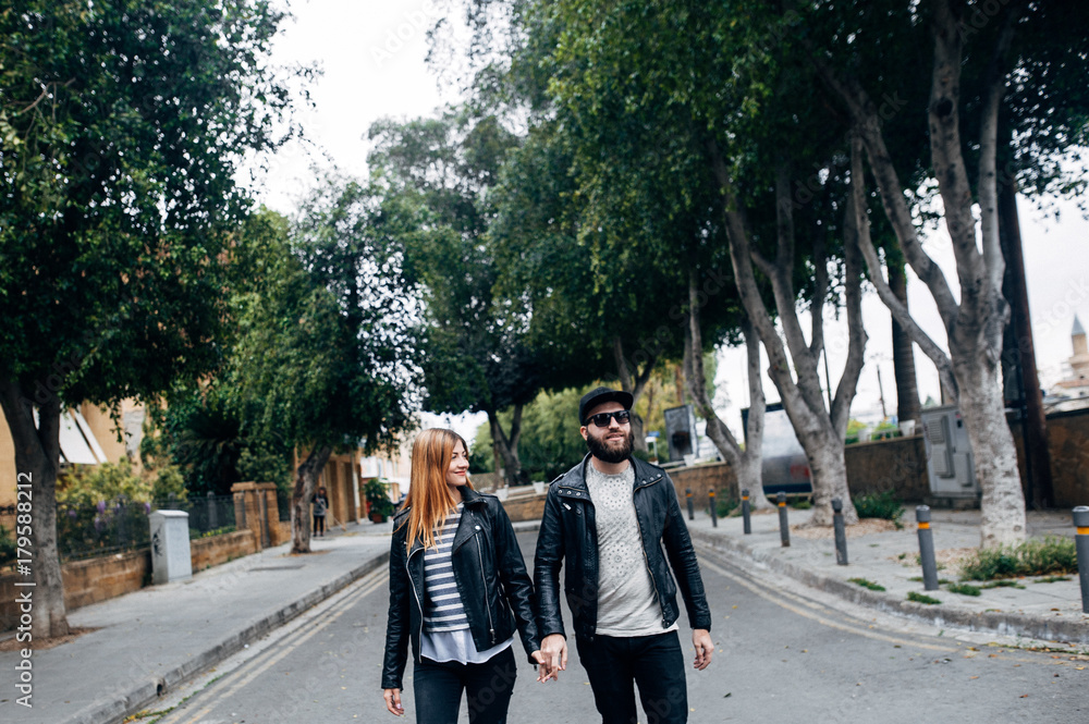 Happy couple in love walking and laughing in the town Happy couple in love walking and laughing in the town