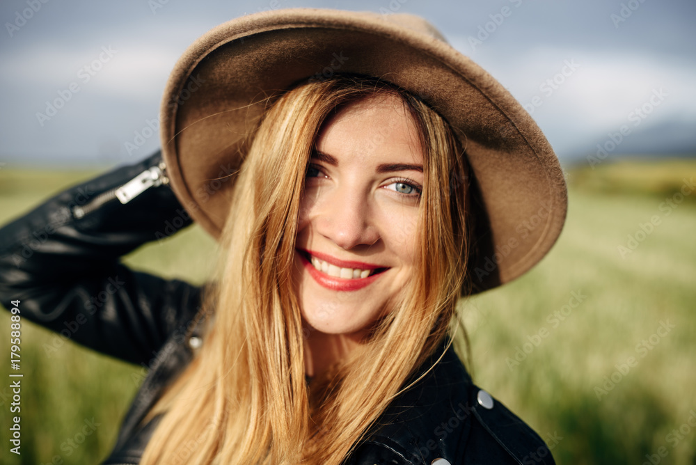 Beautiful smiling girl in a hat on a green field background Beautiful smiling girl in a hat on a green field background