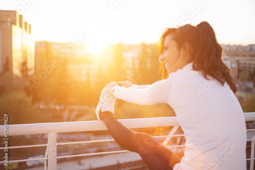 Fitness girl stretching leg on outdoor photo