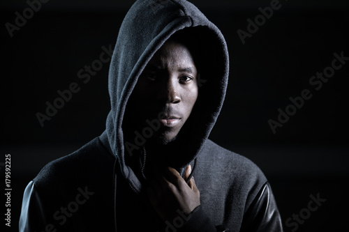 Gangster african man in hood, darkness