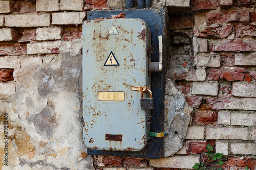 Old rusty electrical box on a brick wall. photo