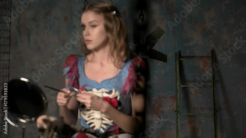 beautiful girl doing makeup before the holiday halloween