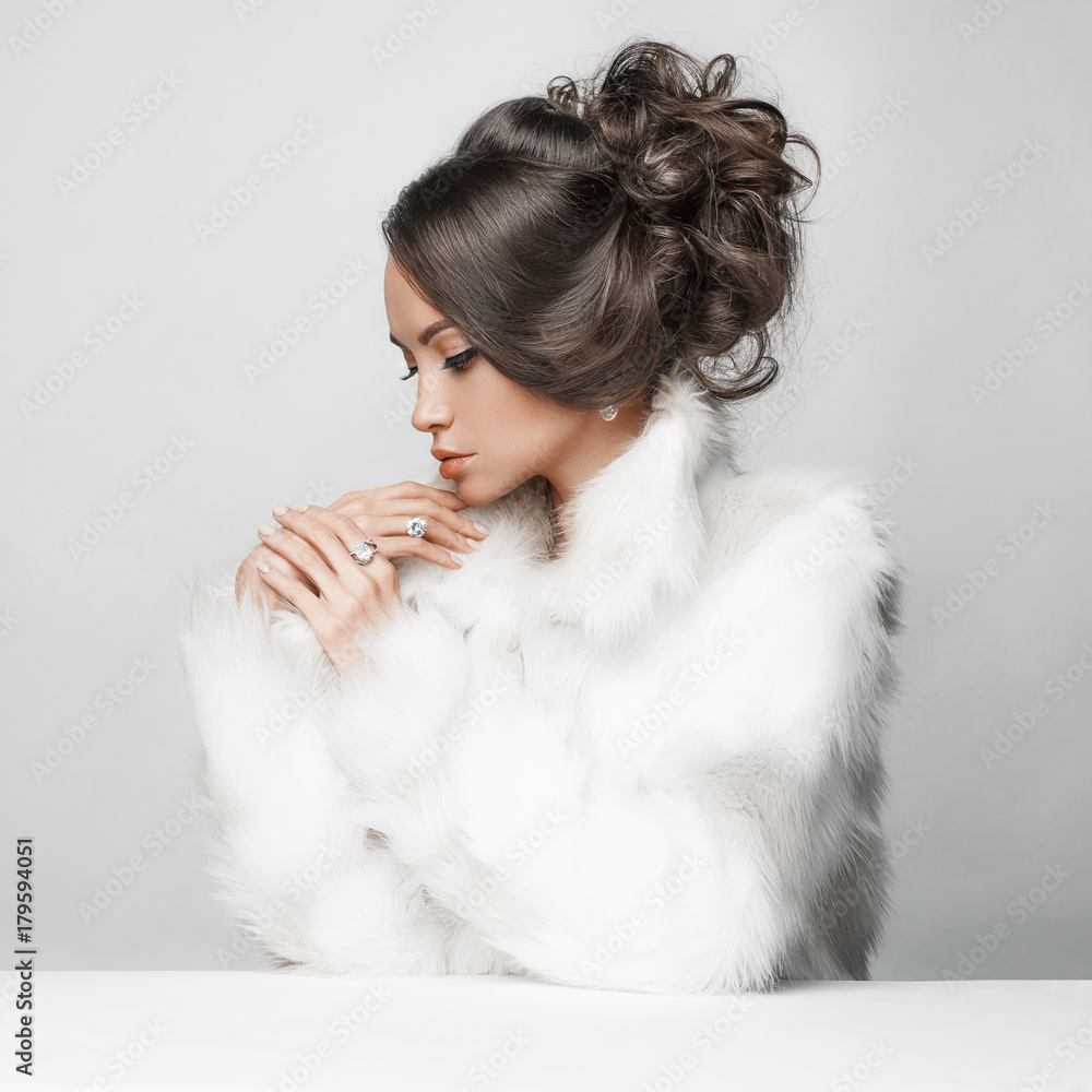 Beautiful woman with elegant hairstyle in white fur coat Beautiful woman with elegant hairstyle in white fur coat