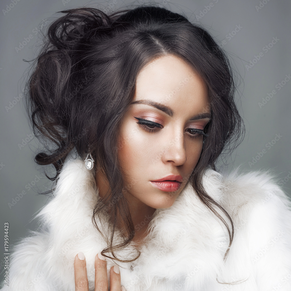 Beautiful woman with elegant hairstyle in white fur coat Beautiful woman with elegant hairstyle in white fur coat