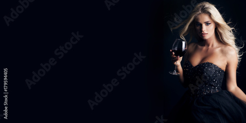 Elegant blonde woman with glass of red wine. Happy New year!