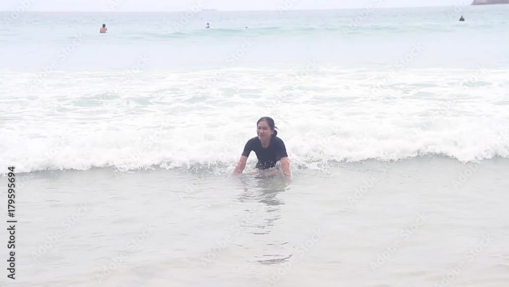 Asian woman play water wave on the beach in summer Asian woman play water wave on the beach in summer