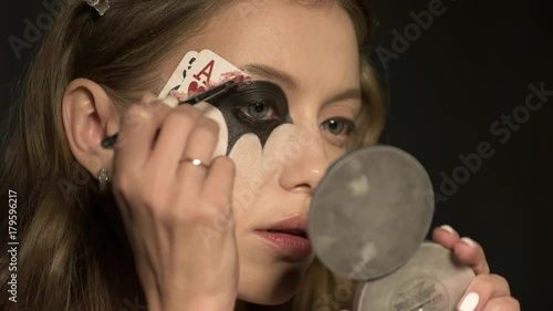 beautiful girl doing makeup before the holiday halloween