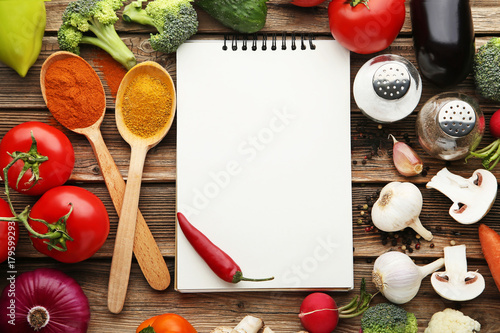 Blank recipe book with vegetables on wooden table