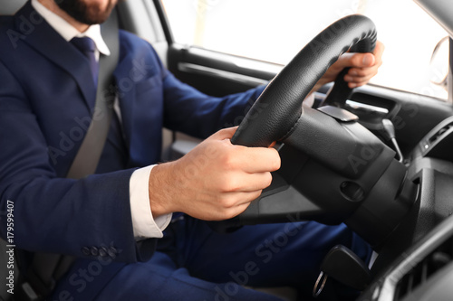 Man in formal suit on driver's seat of car © Africa Studio