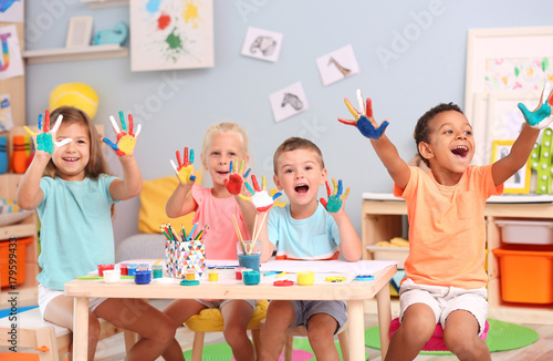 Canvas Print Cute children with painted palms at table indoor