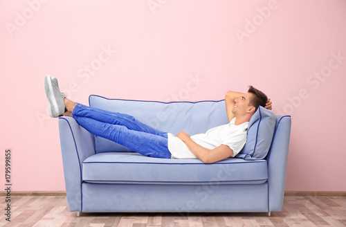 Young man on blue sofa near...