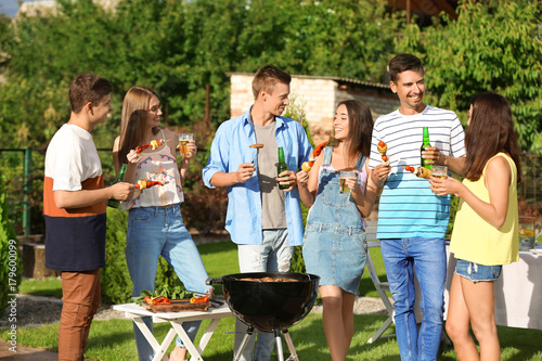 Young friends having barbecue party in garden