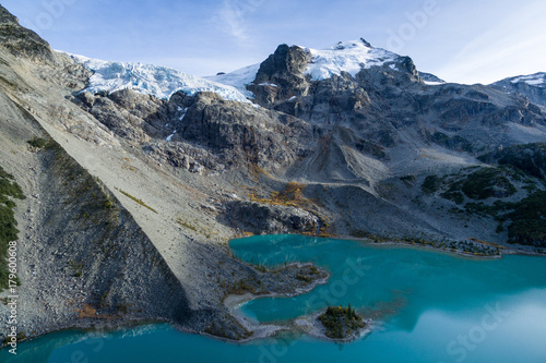 Aerial view of an alpine lake in Canada with a hanging glacier above it