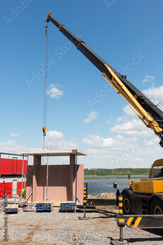 Crane lifting concrete element at construction site