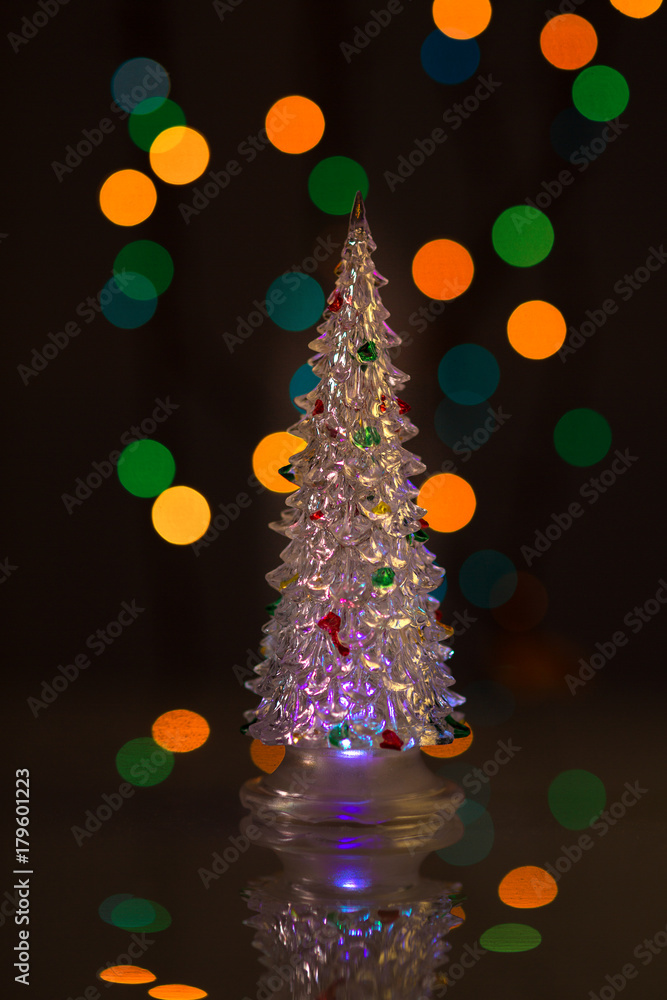 Glowing Christmas tree on black background with colored lights. The silhouette of the tree with the reflection. Beautiful bokeh. For design. Glowing Christmas tree on black background with colored lights. The silhouette of the tree with the reflection. Beautiful bokeh. For design.