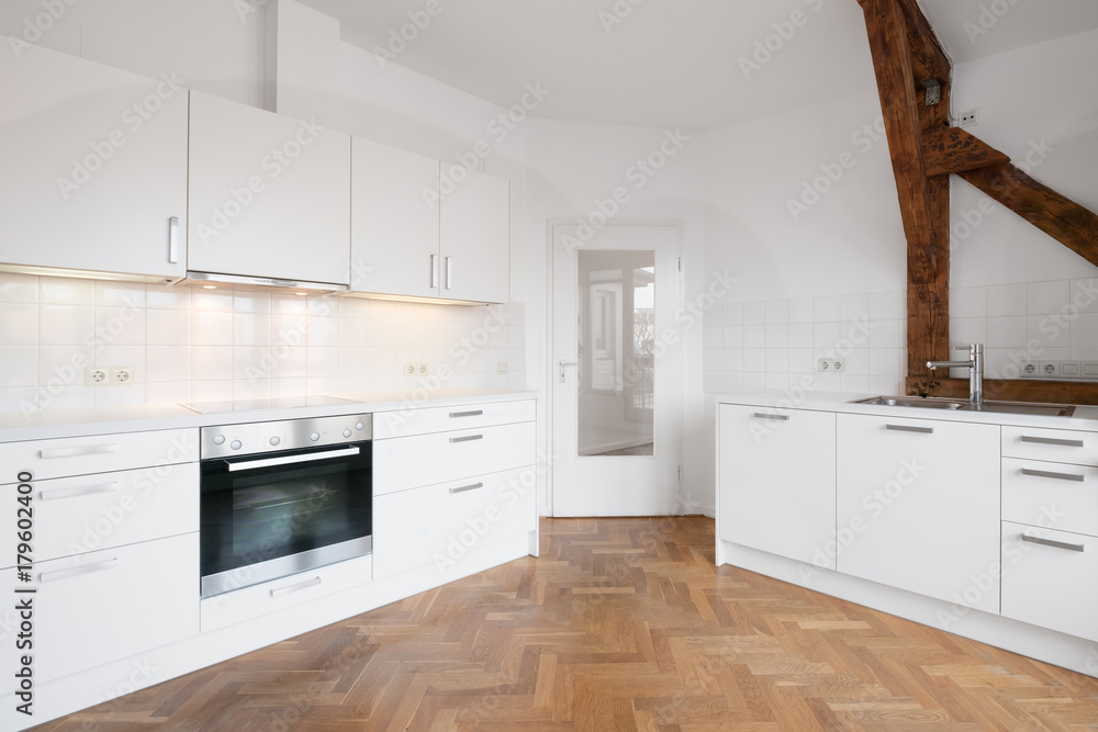 Fototapeta premium modern white kitchen in penthouse flat with wooden floor