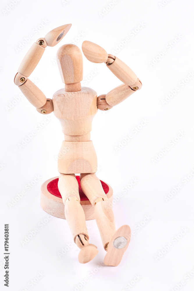Wooden dummy raised hands above head. Human wooden mannequin with raised hand near head sitting over white background. Wooden mannequin in desperation. Wooden dummy raised hands above head. Human wooden mannequin with raised hand near head sitting over white background. Wooden mannequin in desperation.