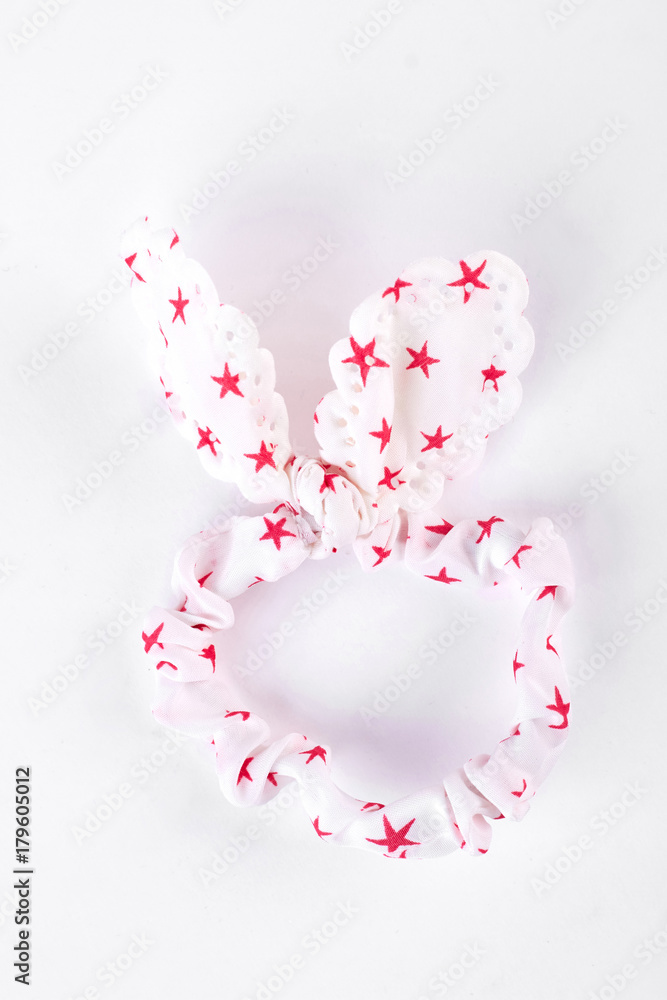 White textile hair scrunchy with a pattern of stars. Child new elastic scrunchy with rabbit ears isolated on white background.