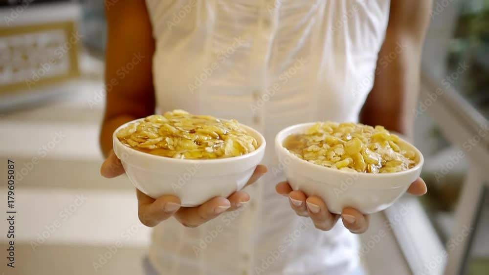 close-up. two female hands carrying plates with a healthy and nutritious Breakfast yogurt with corn flakes and honey close-up. two female hands carrying plates with a healthy and nutritious Breakfast yogurt with corn flakes and honey